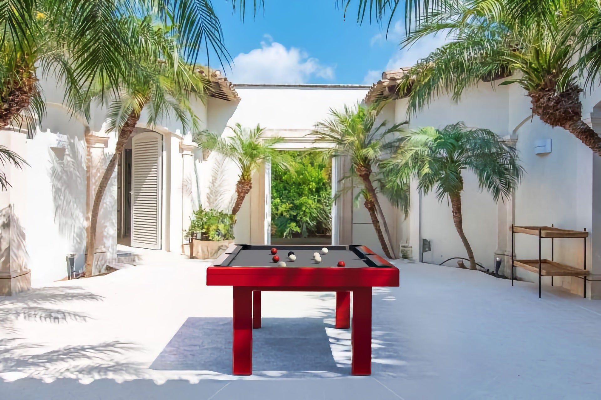 Red outdoor pool table in miami mansion