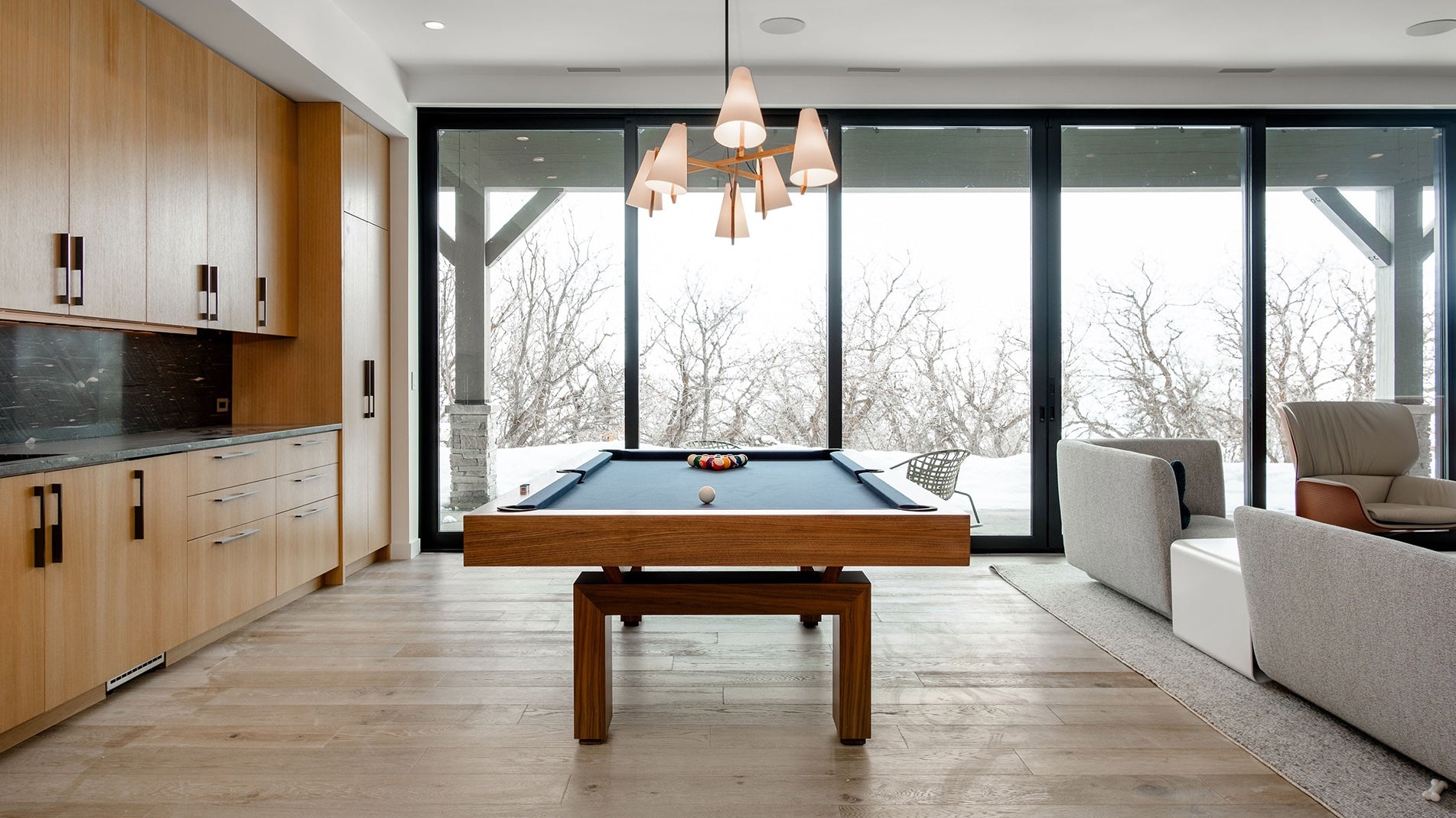 Modern living room with pool table and large windows